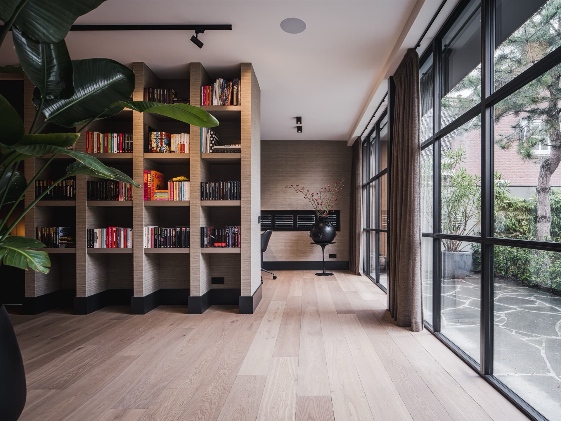 Lichte eikenhouten plankenvloer van Real Dutch Floor in een woonkamer met bibliotheek